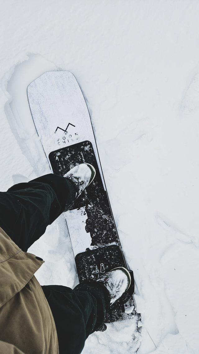 Standing on snowboard with traction pads for powsurfing